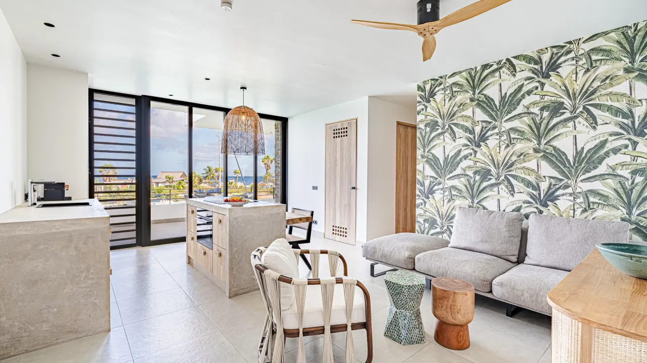 Woonkamer met keuken, zithoek en plafondventilator in het 3-kamerappartement van Van der Valk Bonaire
