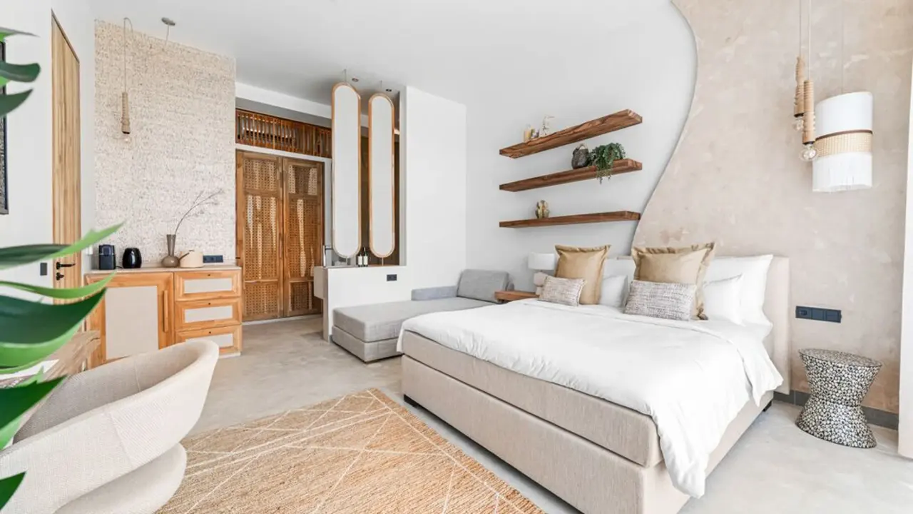 Deluxe Room Garden van Van der Valk Bonaire met kingsize bed, zithoek en houten wandplanken