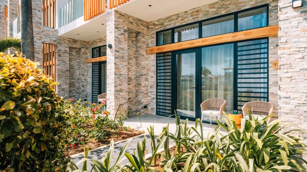 Terras van een Deluxe Room Garden van Van der Valk Bonaire tussen de tropische beplanting
