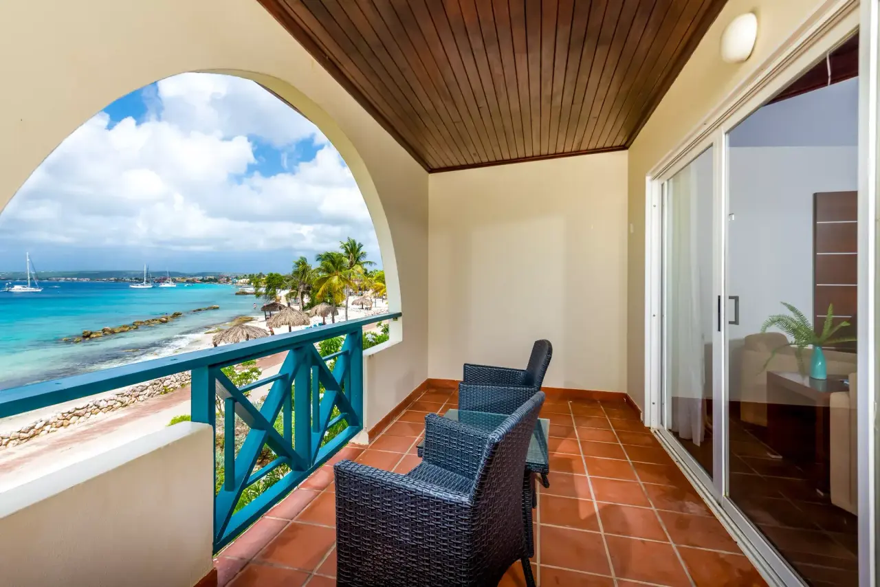 Balkon van een Grand Suite Ocean van Van der Valk Bonaire met boog, terracottategels en uitzicht op zee