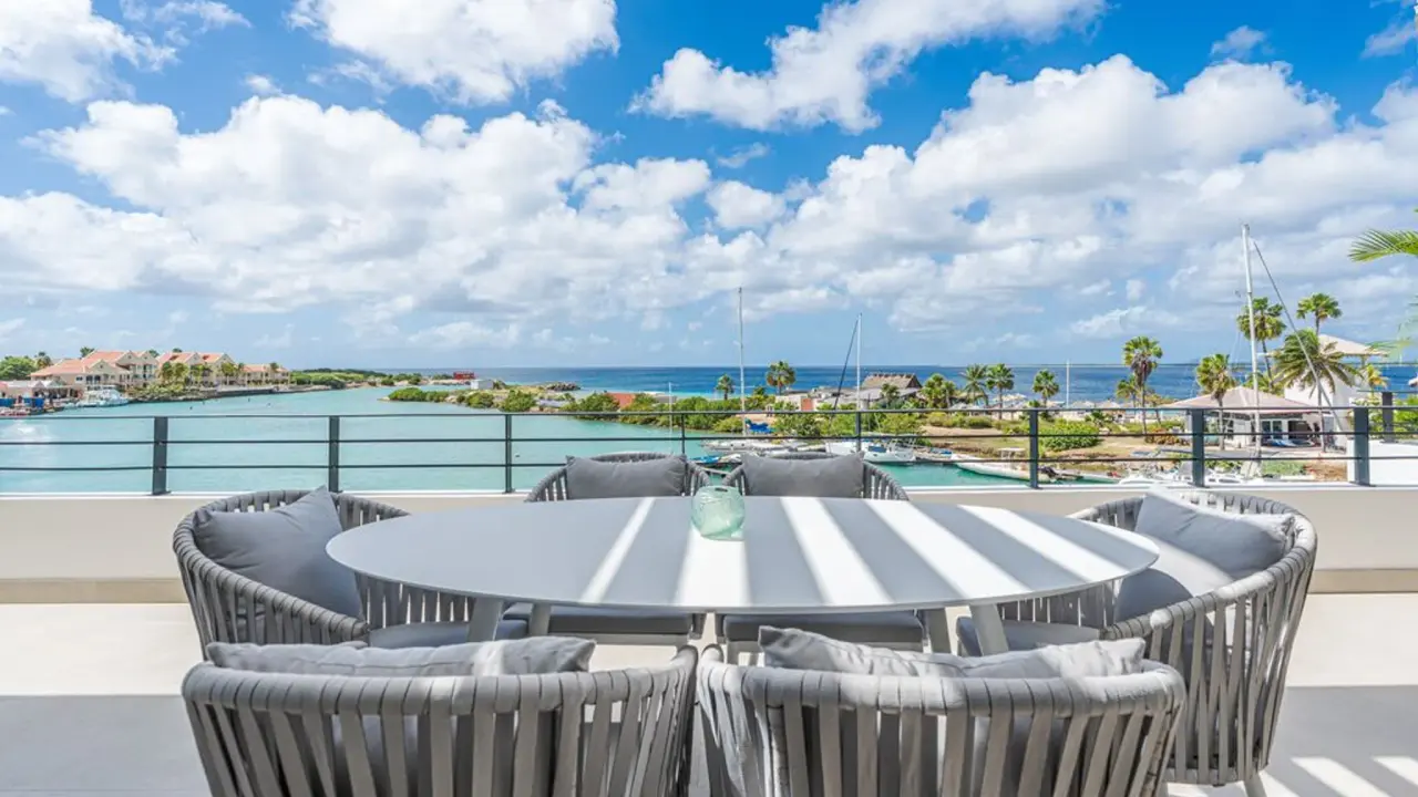 Dakterras van het Penthouse Laguna View van Van der Valk Bonaire met eettafel en uitzicht op lagune en jachthaven