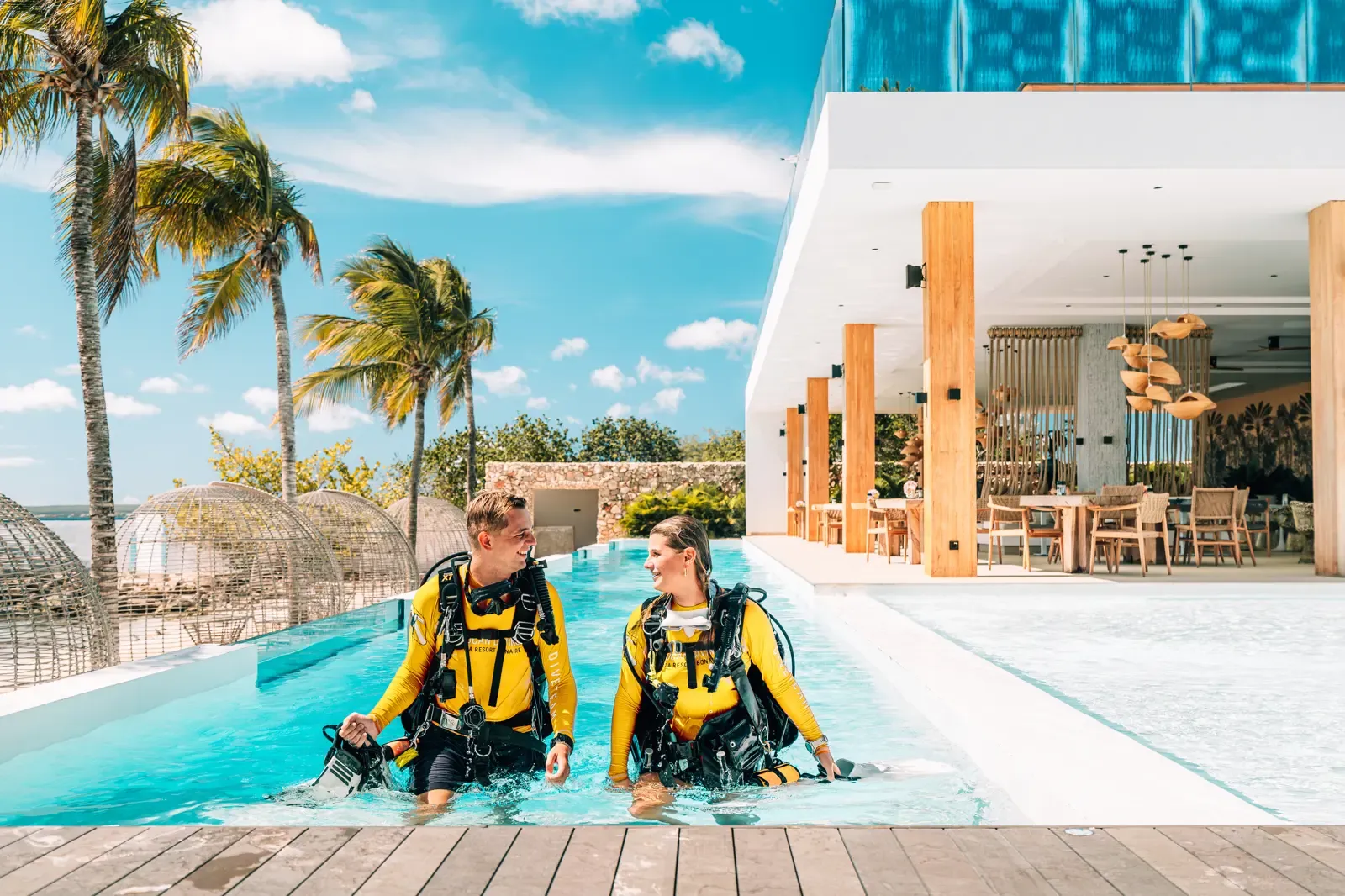 Twee duikers in uitrusting oefenen in het zwembad naast het restaurant van Van der Valk Bonaire