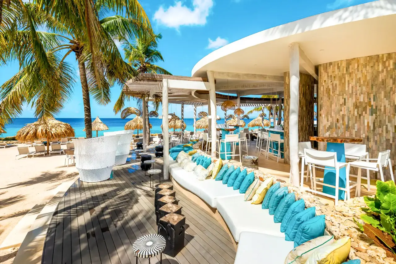 Strandbar van Van der Valk Bonaire met loungebanken en blauwe kussens